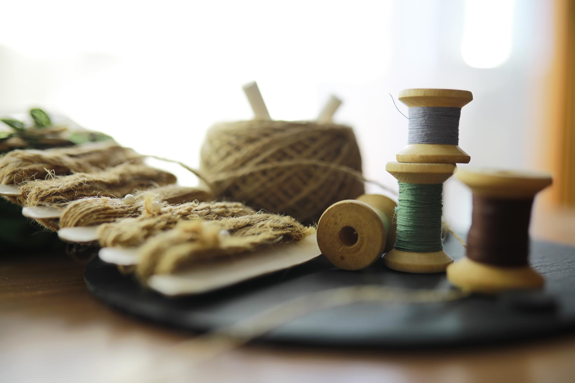 Artisan arranging threads and needles in a studio